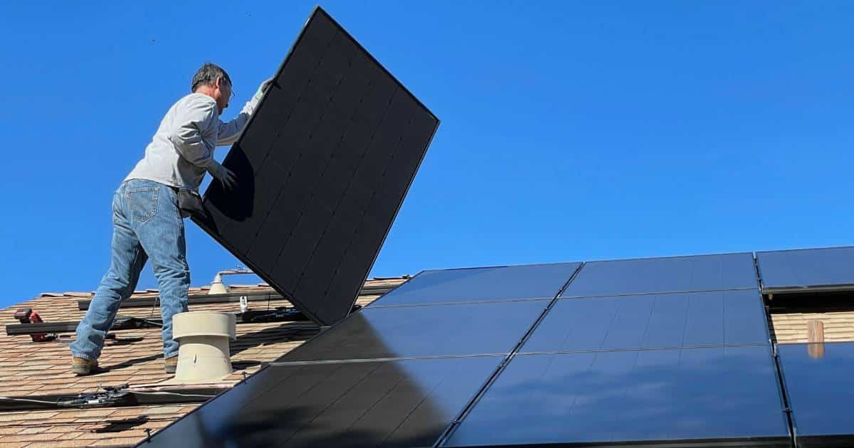 Un ouvrier qui installer des panneaux photovoltaïques pour respecter la
PEB
